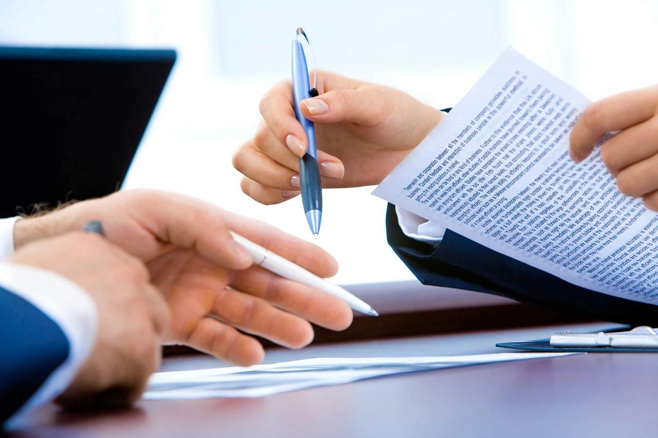 L'image illustre parfaitement des thèmes tels que la négociation de contrats, le conseil stratégique ou la validation de documents officiels.